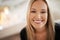 Her smile lights up the room. Portrait of a young woman smiling broadly.