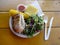 Herb chicken plate with nalo greens salad, corn on the cob, and