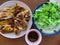 Herb marinated roast chicken with dipping sauce and fresh green vegetables on wooden table, dining table, Asian food concept.