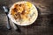 Herb omelette with cheese in white plate on wooden table