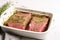 herb rubbed steak in a baking dish ready for oven