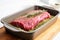 herb rubbed steak in a baking dish ready for oven