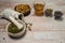 Herbal decoction of calendula and various dried herbs in linen bags and cups on a light wooden background.