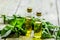 Herbal extract in glass bottles, mint and rosemary for spa on wooden table background