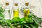 Herbal extract in glass bottles, mint and rosemary for spa on wooden table background