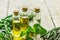 Herbal extract in glass bottles, mint and rosemary for spa on wooden table background