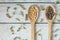 Herbal homeopathy natural pills or vitamins in wooden spoons and dry herbs on white wooden vintage background.