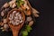 Herbal medicine concept. Herbal drugs in a wooden spoon with different spices on black background and copy space