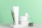 Herbal natural cosmetics white plastic unbranded bottles composition. Blank skincare products containers on pastel green