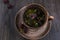 Herbal tea, herbs and flowers in a clay cup on wooden table