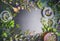 Herbal tea ingredients with various fresh herbs and flowers, cup of tea and tools on black chalkboard background