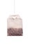 Herbal tea in paper bag. Teabag hanging against white background