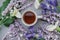 Herbal tea with wisteria, irises, white callas on gray background.