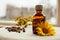Herbal tincture in pharmacy bottle and yellow flower of calendula with tansy at background and wild dry berries at linen textile,