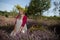 A herbalist sits among the heather wearing a garland of goldenrod flowers. Field herbs.