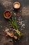 Herbs bunch thyme and condiments on old black wooden table. Thyme, sea salt and pepper. Top view with copy space