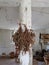 Herbs drying on white pole in white room with buckets