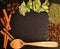 Herbs in kitchen, frame of spices, cinnamon sticks, star anise, wooden spoon, Various spices on stone black table