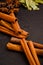 Herbs in kitchen, frame of spices, cinnamon sticks, star anise, wooden spoon, Various spices on stone black table