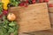 Herbs and vegetables with a blank chopping board. Space for copy