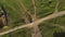 A herd of sheep crosses the road to get to pasture on green field, car passes the animals, top view, drone shooting from