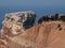 Herd of sheep perched atop a high cliff overlooking a tranquil body of water