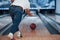 Here we go. Rear particle view of man in casual clothes playing bowling in the club