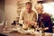 Here, have some of this salad. an elderly couple dishing up a meal in their kitchen at home.