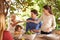 Heres some for you grandma. A view of a family preparing to eat lunch together outdoors.