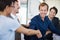 Heres to another job well done. two business people shaking hands while sitting at a table.