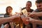 Heres to the best summer ever. a group of happy young friends toasting with their drinks while relaxing on the beach.