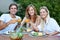 Heres to friendship. Smiling young people having lunch together - portrait.