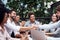 Heres to new business partners. two handsome young businessmen shaking hands while sitting with their colleagues