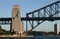 Heritage steel truss arch bridge and towering pylon structure on waterfront. Iconic Sydney Harbor Bridge, Australia.