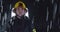 Hero shot, portrait of tired American female firefighter standing taking off her protective helmet, looking into camera