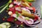 Herring appetizer with beets and gherkin on black slate board