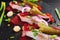 Herring appetizer with beets and gherkin on black slate board