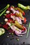 Herring appetizer with beets and gherkin on black slate board