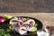 Herring fillet with pepper, rosemary, onion and lime on black plate on rustic wooden background. close up