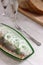 A herring with onions and dill in a glass plate, served with bread and vodka. Soviet life. Rustic style, selective focus.