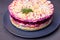 Herring salad under a fur coat. Traditional Russian multilayered salad from herring, beets, potatoes, carrots and eggs. Close-up.