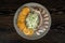 Herring sliced with onions and baked potatoes on a gray plate on a dark wooden table. Top view