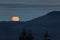 Hervest supermoon rising over the mountains