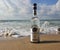 Herzelia, Israel. December 17, 2016. Bottle of Beluga vodka in water, beach sand and wave seashore background. Waves wash a glass