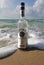 Herzelia, Israel. December 17, 2016. Bottle of Beluga vodka in water, beach sand and wave seashore background. Waves wash a glass