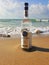 Herzelia, Israel. December 17, 2016. Bottle of Beluga vodka in water, beach sand and wave seashore background. Waves wash a glass