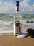 Herzelia, Israel. December 17, 2016. Bottle of Beluga vodka in water, beach sand and wave seashore background. Waves wash a glass