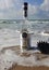 Herzelia, Israel. December 17, 2016. Bottle of Beluga vodka in water, beach sand and wave seashore background. Waves wash a glass