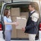 Hes committed to great customer service. a delivery man making a delivery to a customer at her home.