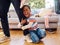 Hes having a bad day. a little boy throwing a tantrum while holding his parents leg at home.